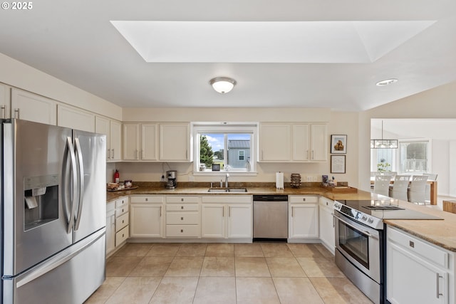 kitchen with sink, light tile patterned floors, stainless steel appliances, and kitchen peninsula