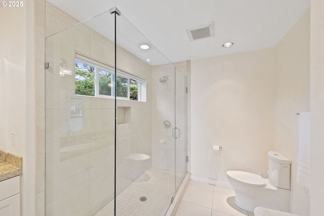 bathroom with tile patterned floors, toilet, a shower with shower door, and vanity