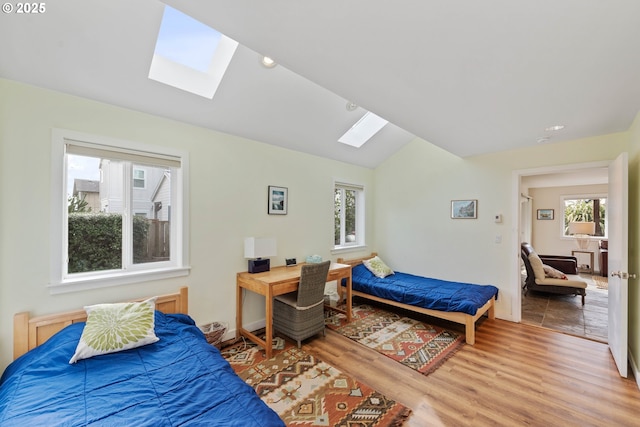 bedroom with hardwood / wood-style flooring and vaulted ceiling with skylight