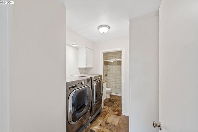 washroom with cabinets and washing machine and clothes dryer