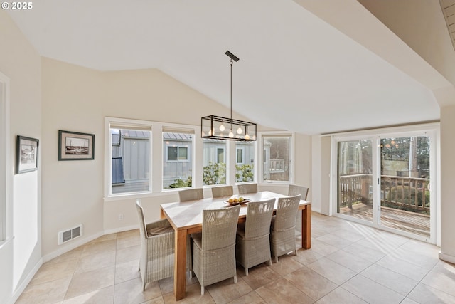 tiled dining area featuring an inviting chandelier and vaulted ceiling