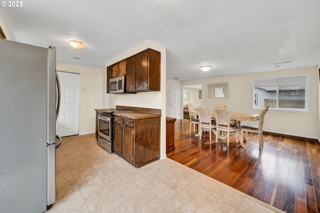 2280 Dakota St, Eugene, OR 97402 - kitchen with stainless steel appliances, baseboards, and dark brown cabinets