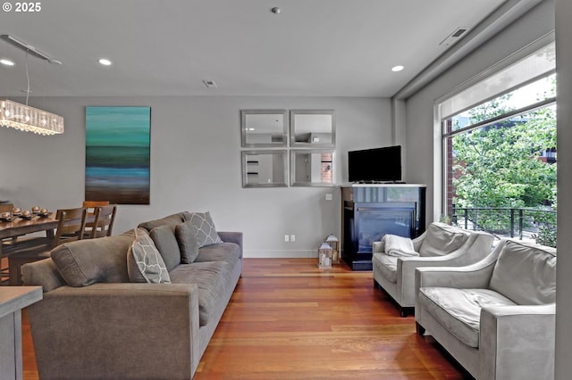 1746 NW Riverscape St, Portland, OR 97209 - living room with light wood-style floors, a glass covered fireplace, recessed lighting, and baseboards
