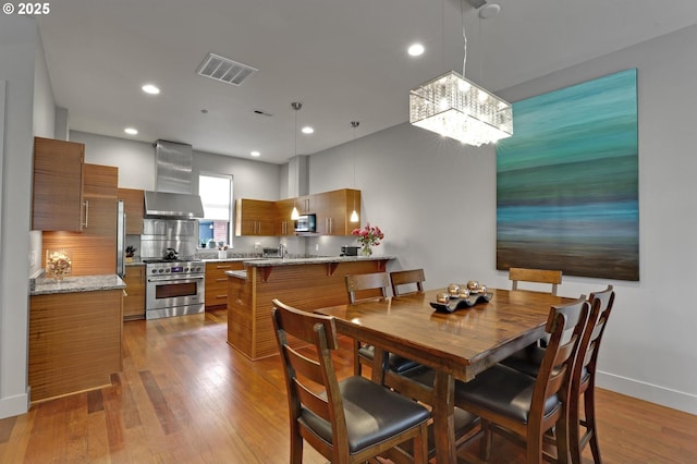 1746 NW Riverscape St, Portland, OR 97209 - dining room with a chandelier, wood finished floors, baseboards, and recessed lighting