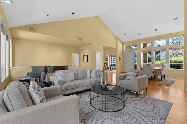 living room with high vaulted ceiling and light hardwood / wood-style floors