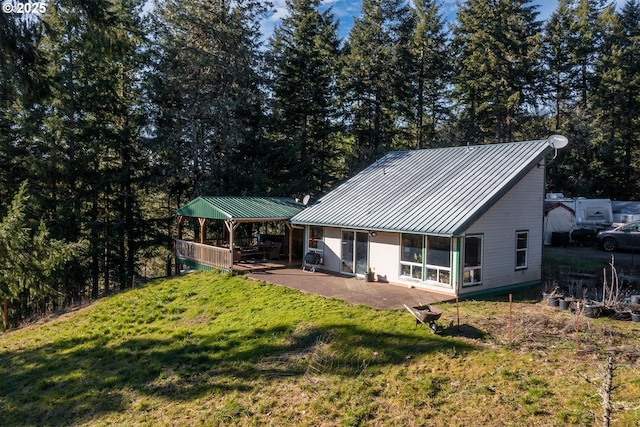 rear view of house featuring a gazebo, a lawn, and a patio