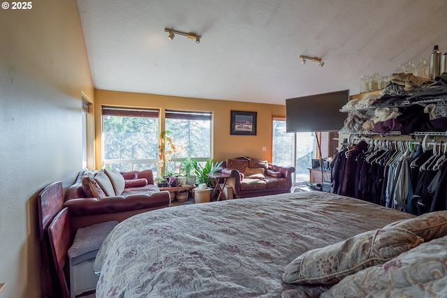 bedroom featuring rail lighting and a textured ceiling