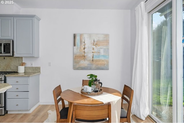 dining area featuring light wood-type flooring and baseboards