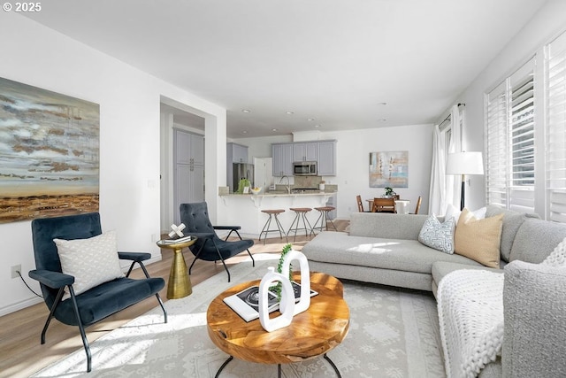 living area featuring light wood-style flooring and baseboards