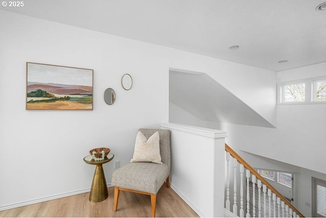 living area with wood finished floors, an upstairs landing, and baseboards