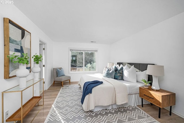 bedroom featuring baseboards and wood finished floors