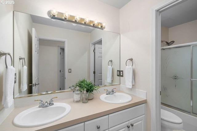 bathroom with enclosed tub / shower combo, double vanity, a sink, and toilet