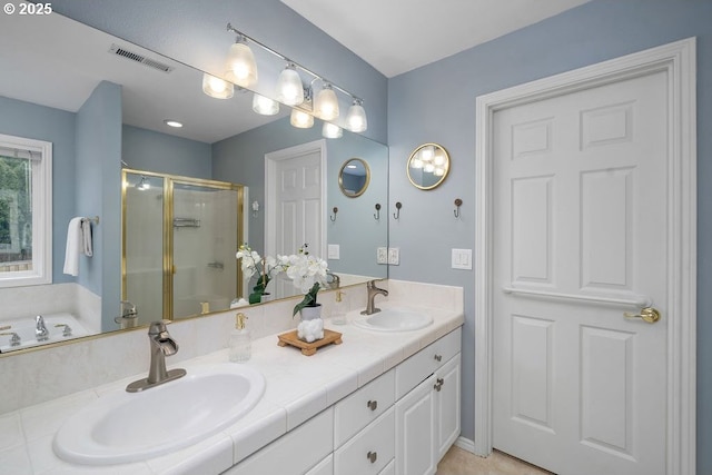 bathroom with double vanity, a shower stall, visible vents, and a sink