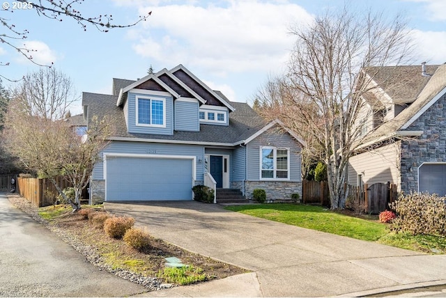 craftsman-style home with driveway, a shingled roof, stone siding, an attached garage, and fence