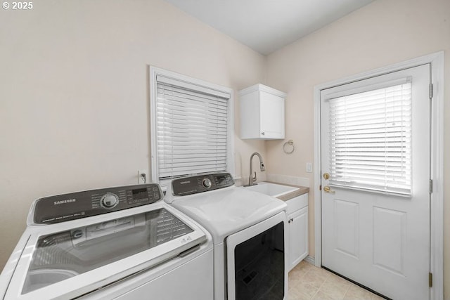 laundry room featuring cabinet space, washing machine and dryer, and a sink