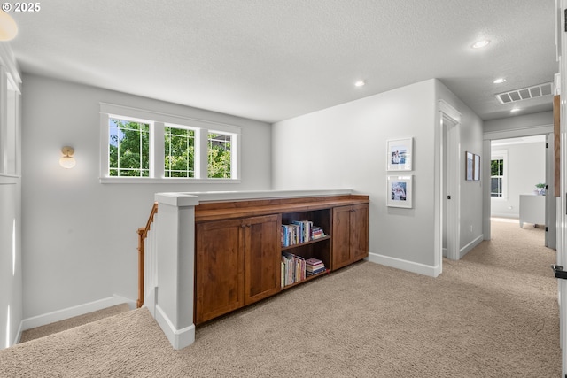 hall featuring baseboards, light colored carpet, recessed lighting, healthy amount of natural light, and a textured ceiling