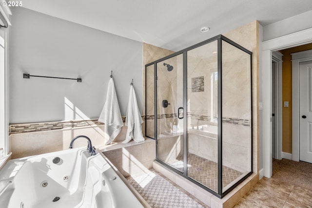 bathroom with a shower stall, a jetted tub, and tile patterned floors