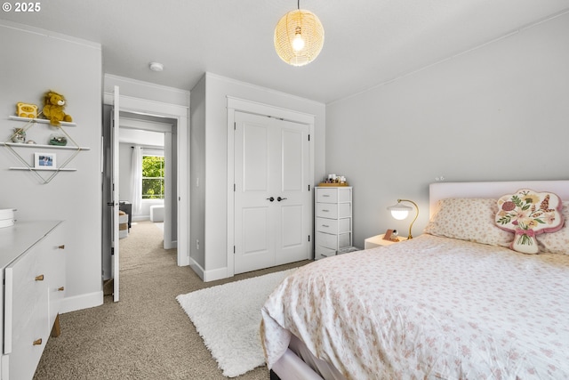 bedroom with carpet flooring, a closet, baseboards, and ornamental molding