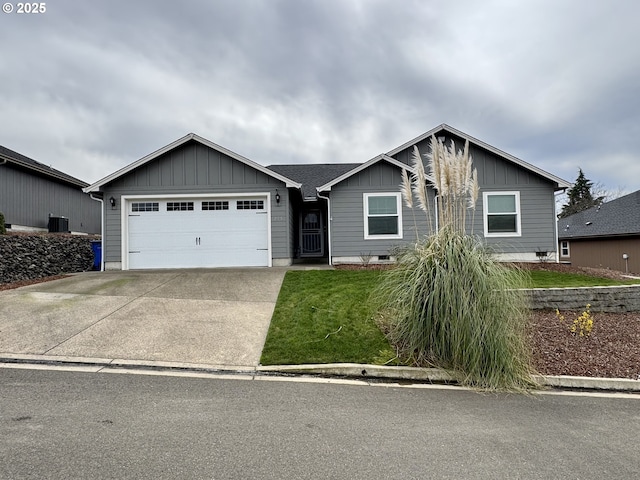 ranch-style house with board and batten siding, an attached garage, driveway, and a front lawn