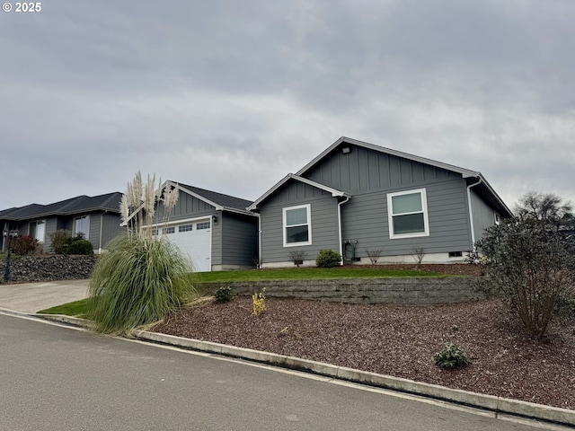 ranch-style home with driveway, board and batten siding, and an attached garage