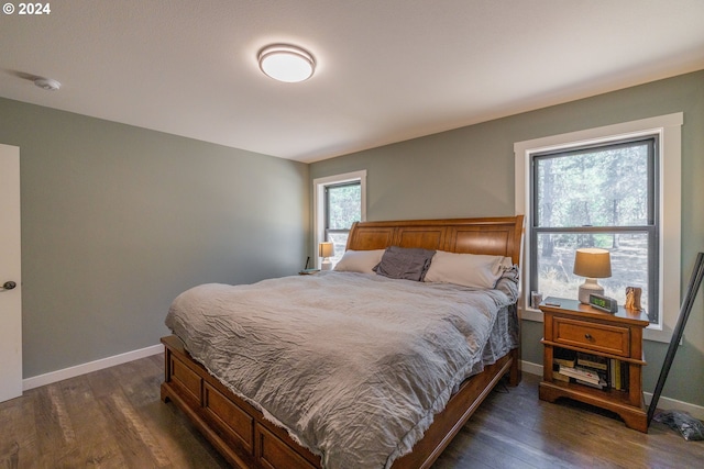 bedroom featuring dark wood finished floors and baseboards