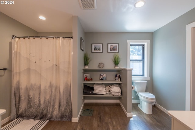 full bathroom featuring curtained shower, visible vents, toilet, wood finished floors, and baseboards