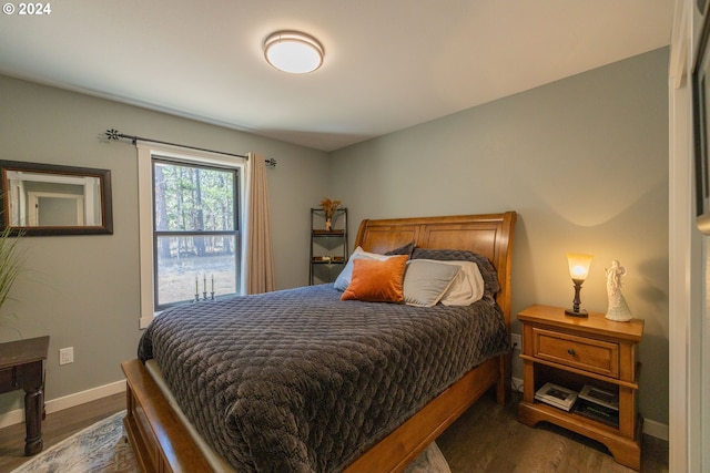 bedroom with dark wood-style floors and baseboards