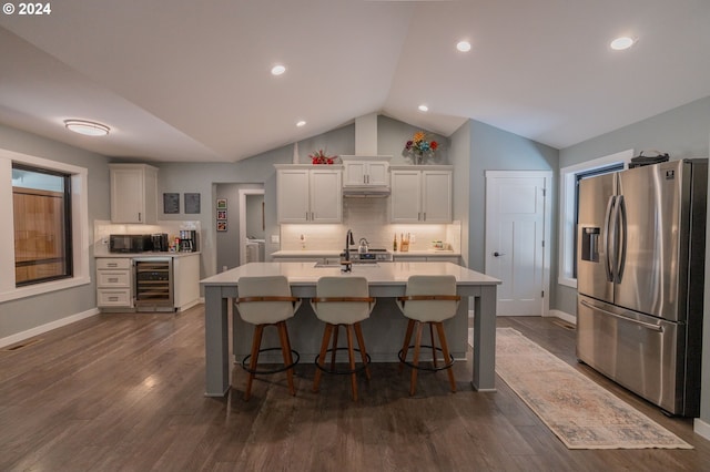 kitchen with black microwave, beverage cooler, white cabinetry, light countertops, and stainless steel fridge