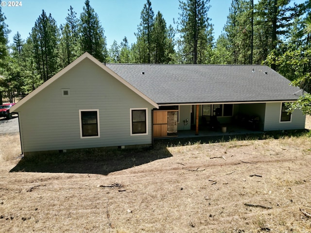 rear view of property with a shingled roof