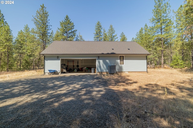 garage featuring central AC unit and gravel driveway