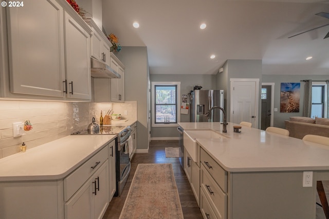 kitchen featuring light countertops, appliances with stainless steel finishes, backsplash, and under cabinet range hood