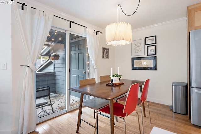 dining space with light wood-type flooring and crown molding