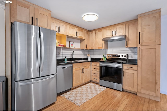 kitchen featuring backsplash, stainless steel appliances, sink, light brown cabinets, and light hardwood / wood-style flooring