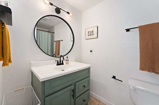 bathroom with tile patterned flooring, vanity, and toilet