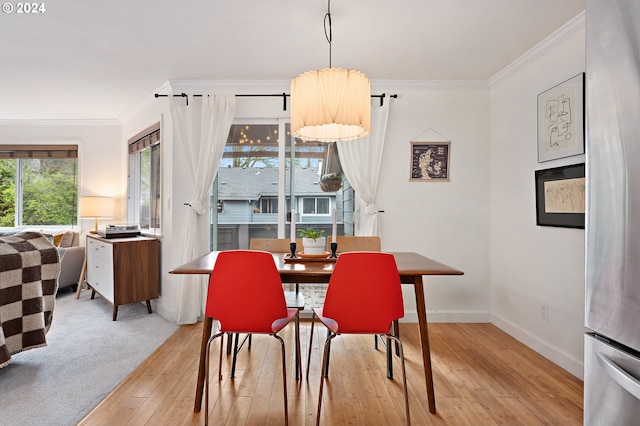 dining area featuring light hardwood / wood-style floors and crown molding