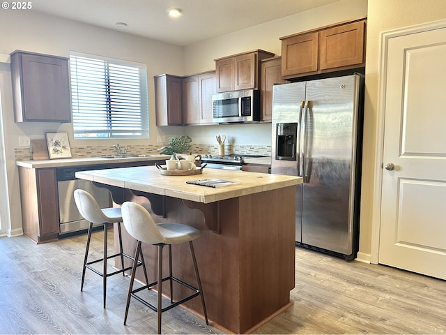 12972 SE 156th Ave, Happy Valley, OR 97086 - kitchen featuring stainless steel appliances, light countertops, a center island, a kitchen bar, and a sink