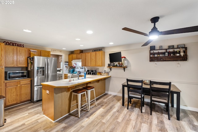 816 SW Chablis Ct, Dundee, OR 97115 - kitchen with appliances with stainless steel finishes, a peninsula, light wood-style flooring, a breakfast bar, and recessed lighting