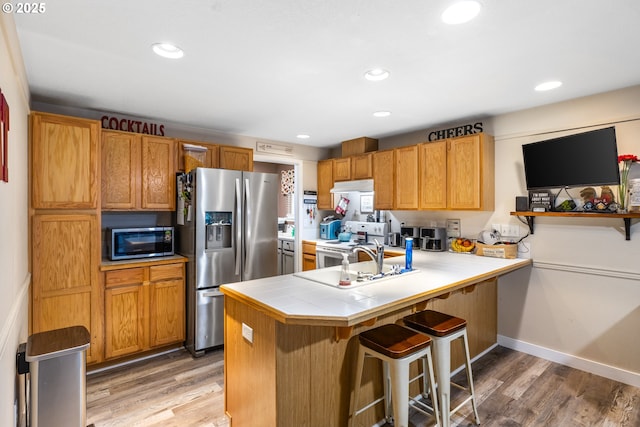 816 SW Chablis Ct, Dundee, OR 97115 - kitchen featuring stainless steel fridge with ice dispenser, a kitchen breakfast bar, light wood-type flooring, a peninsula, and white electric range