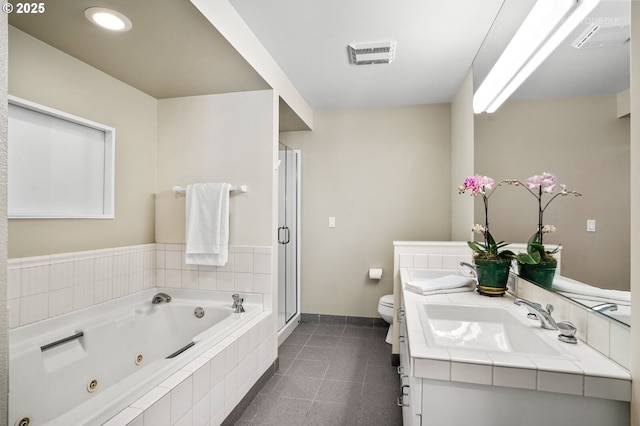 full bath featuring toilet, a tub with jets, double vanity, baseboards, and a stall shower