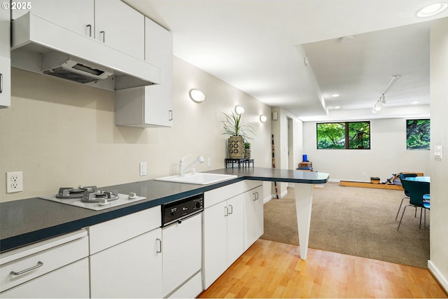 kitchen featuring a sink, open floor plan, a peninsula, white gas cooktop, and light wood-style floors