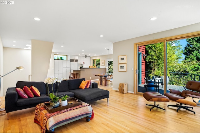 living area featuring light wood-style floors, recessed lighting, and baseboards