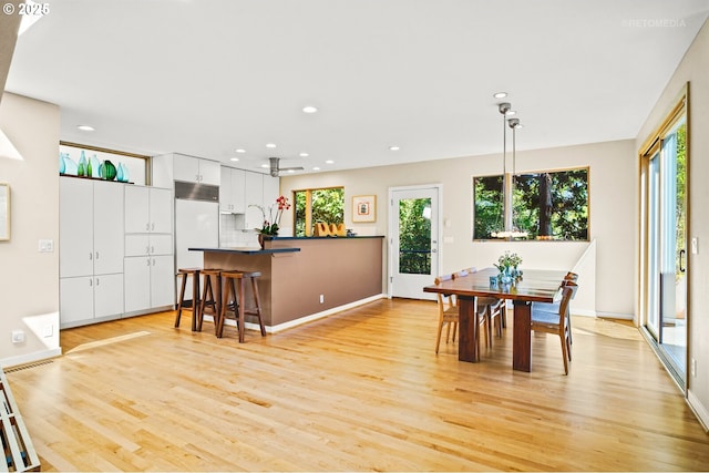 dining space featuring healthy amount of natural light, light wood-style floors, recessed lighting, and baseboards