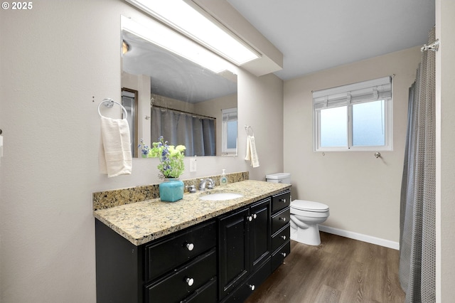 bathroom with wood finished floors, toilet, baseboards, and vanity