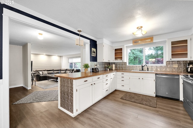 kitchen featuring stainless steel dishwasher, wood finished floors, a peninsula, range with electric stovetop, and open floor plan