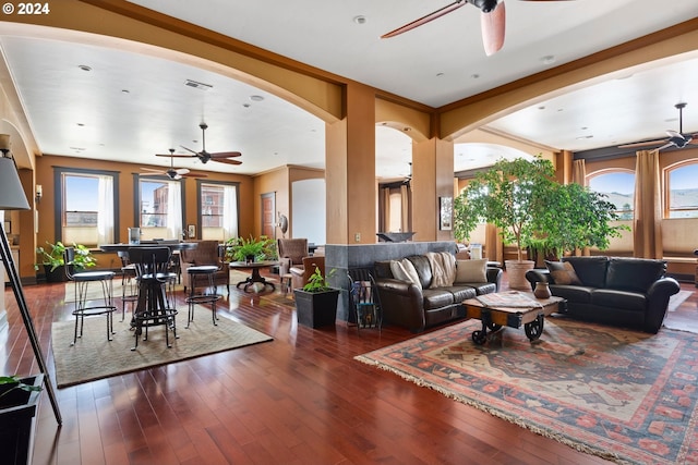 living area featuring ceiling fan, visible vents, arched walkways, and hardwood / wood-style floors