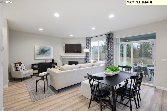 dining area featuring a fireplace and light hardwood / wood-style floors