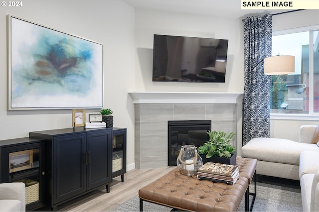 living room with a fireplace and light wood-type flooring