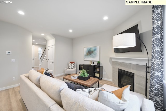 living room with light hardwood / wood-style floors and a tile fireplace