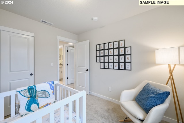 carpeted bedroom with a nursery area