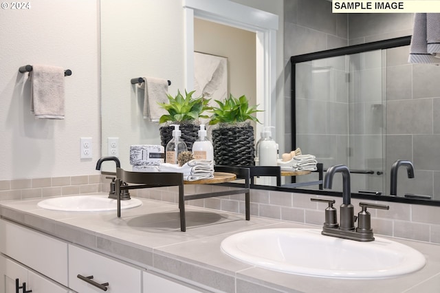 bathroom with vanity and a shower with door